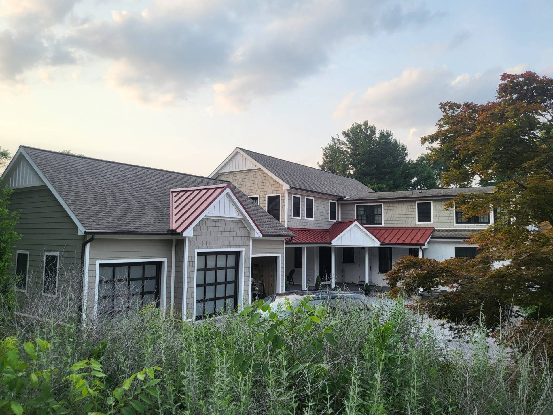 Exterior view of custom addition designed by Brad M. Zahm, RA, NCARB and The Mula Group. Three-car garage is attached to the addition by a breezeway with a red metal roof.