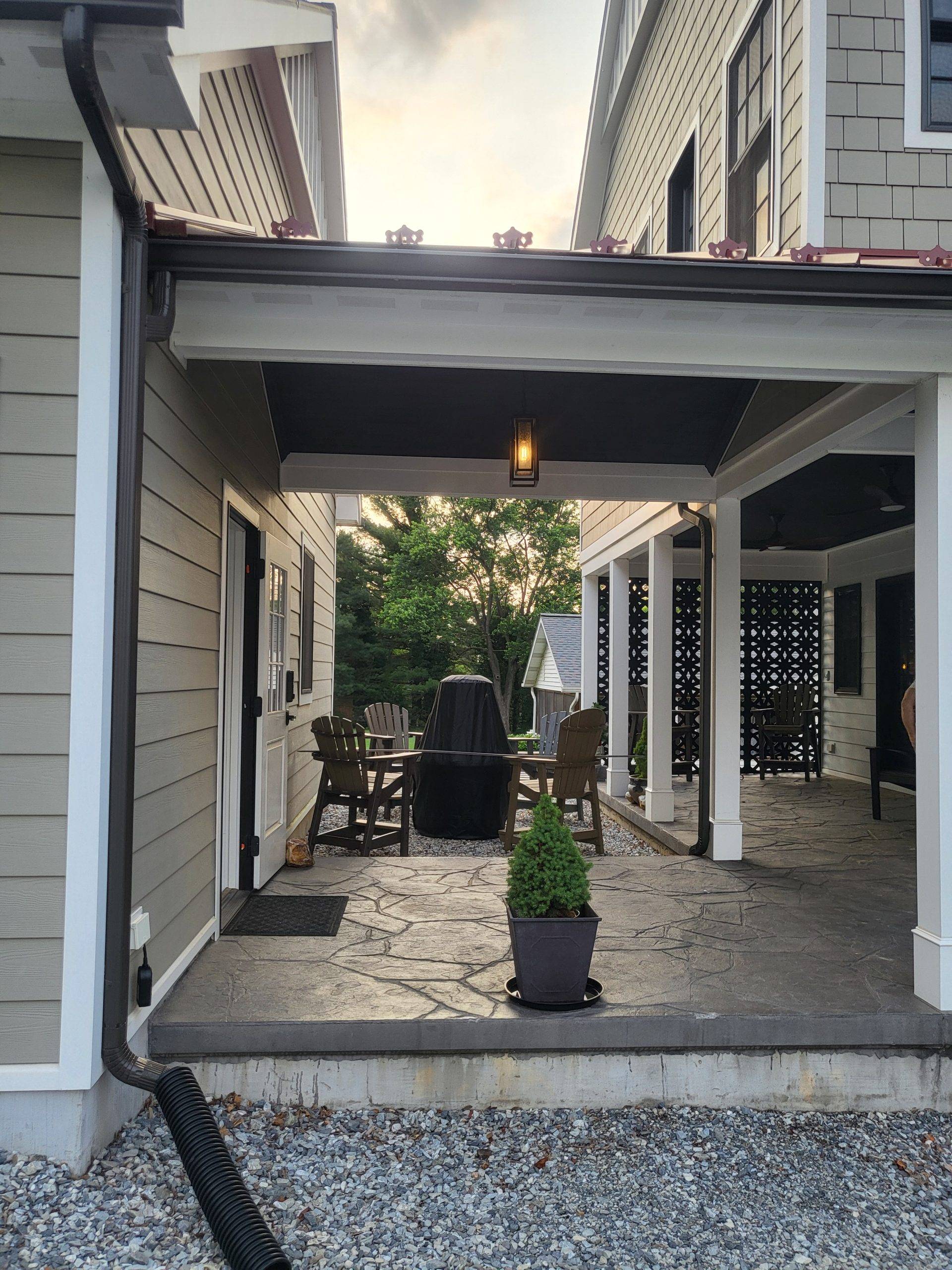 Stamped concrete under breezeway connecting garage to addition. Patio includes a privacy wall and firepit area. Designed by Brad M. Zahm, RA, NCARB and The Mula Group.