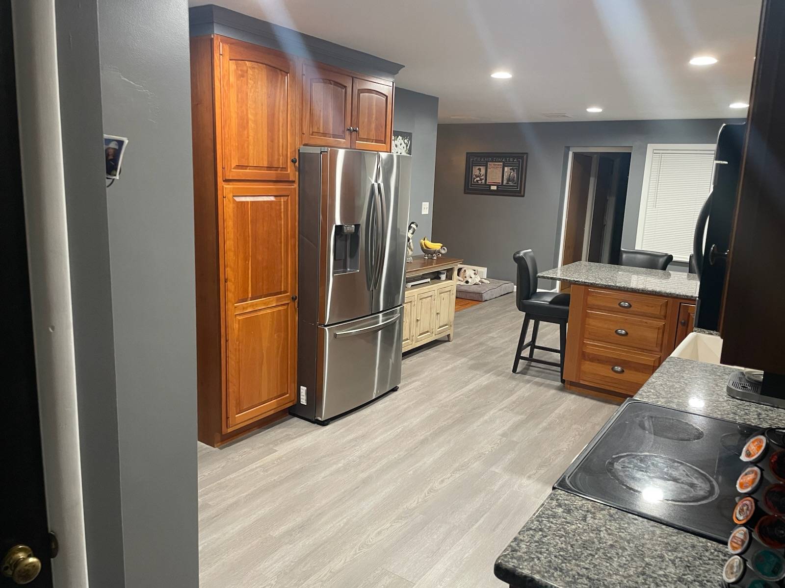 Renovated kitchen view of new floor-to-ceiling cabinets and french door refrigerator.