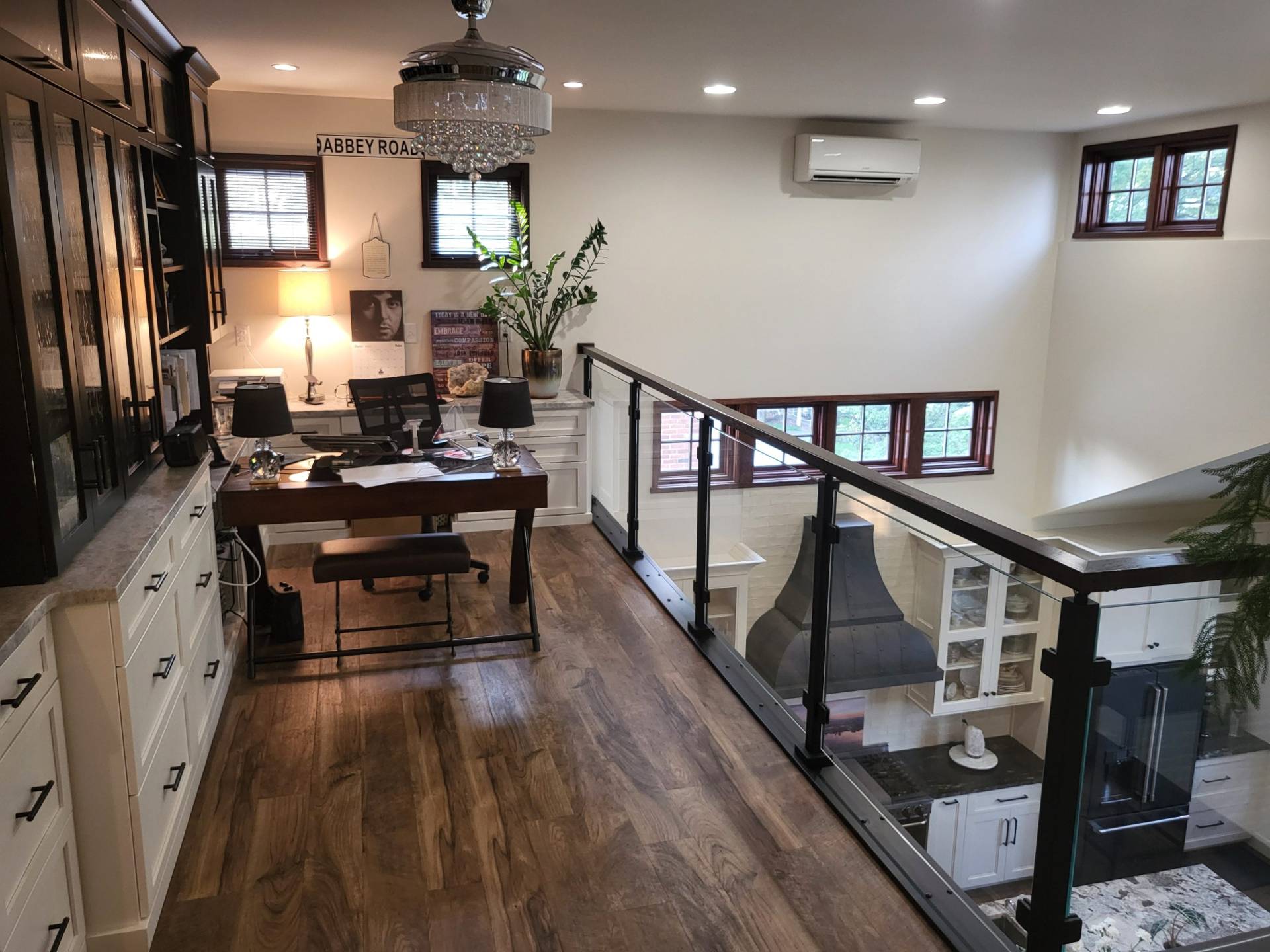 View from the top of the stairs of the second floor library with glass railing overlooking the kitchen. Designed by Brad M. Zahm, RA, NCARB and The Mula Group.