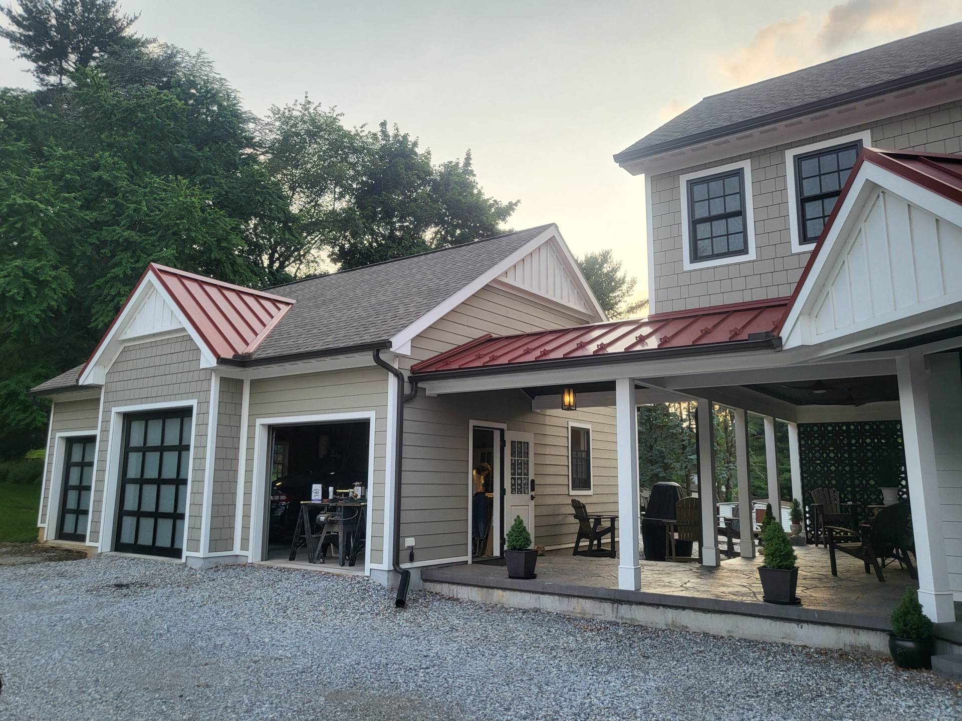 Exterior view of red metal roof breezeway connecting addition to the three-car garage. Designed by Brad M. Zahm, RA, NCARB and The Mula Group.